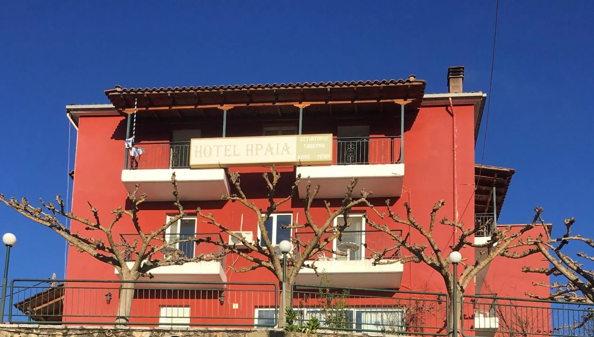Η κόκκινη πρόσοψη του ξενοδοχείου με τα μπαλκόνια